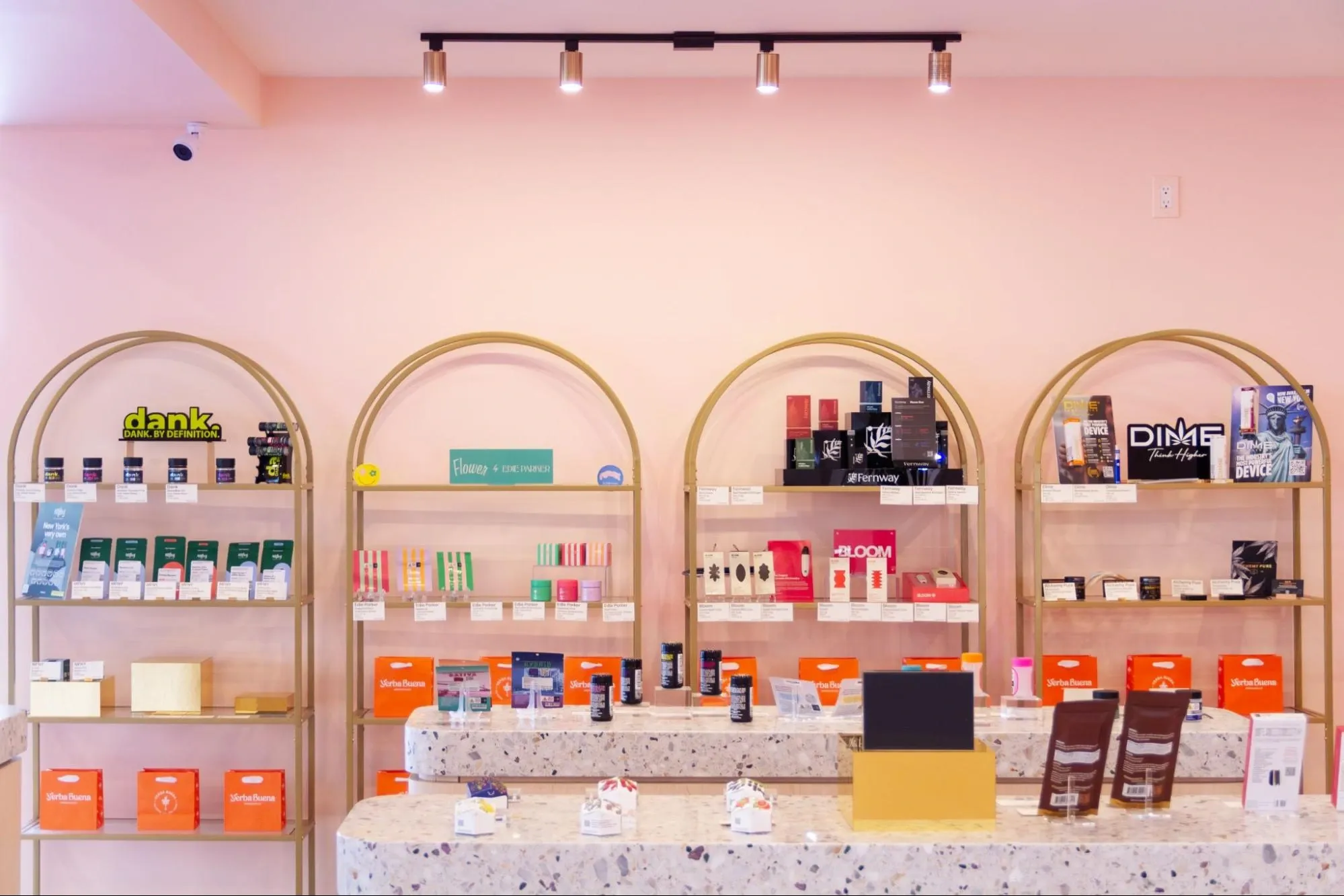 Different cannabis products displayed on shelves inside the pink interior of licensed dispensary Yerba Buena